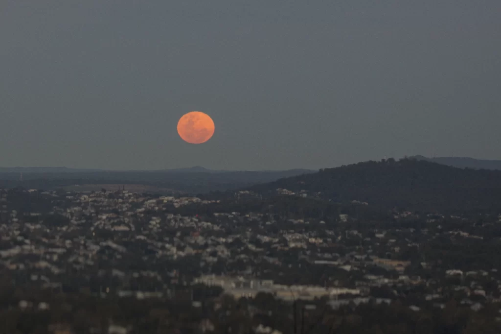 Full Moon rising over Brisbane in the last violet-blue light