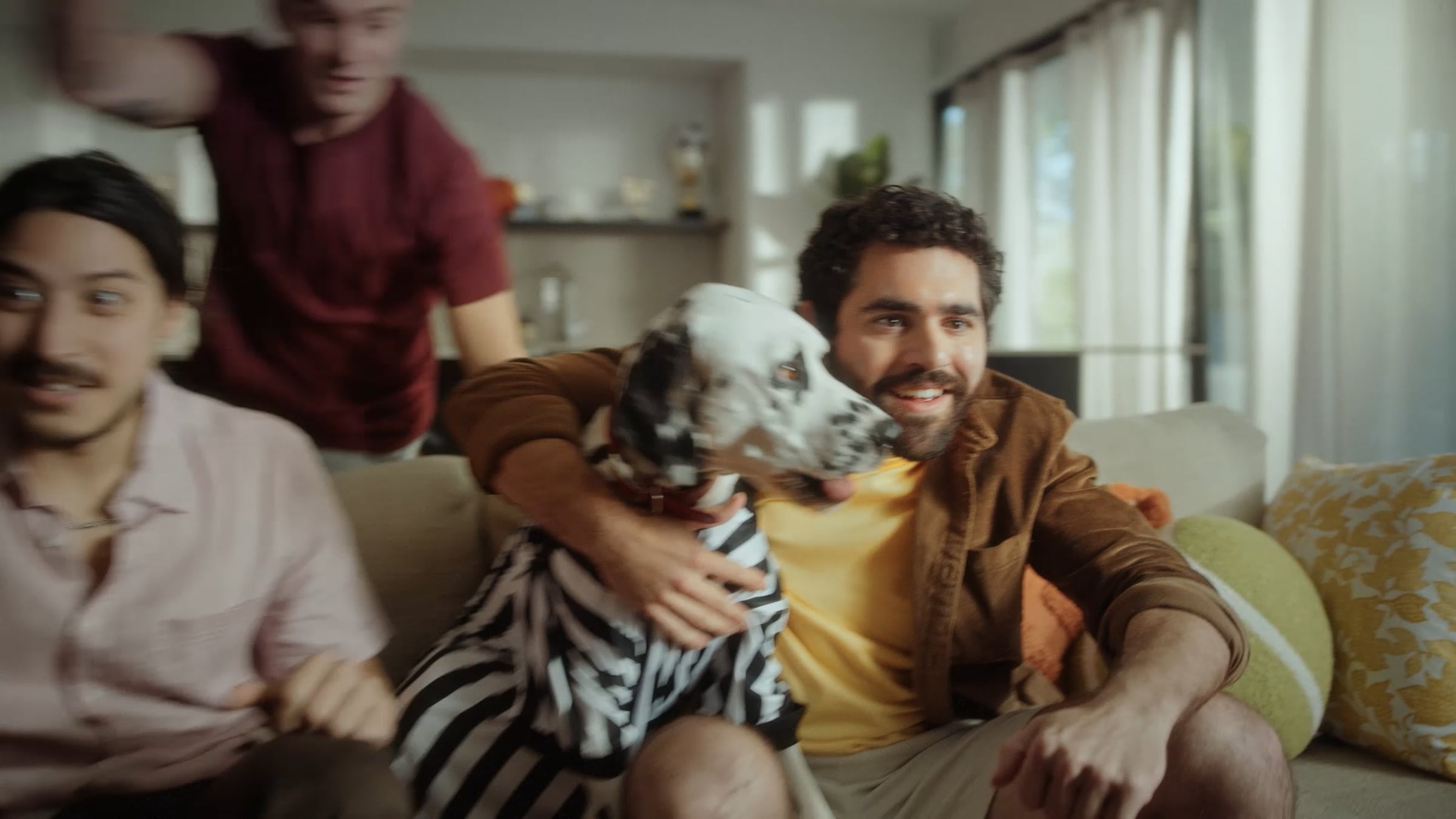 Campaign still showing a group watching together on a sofa.
